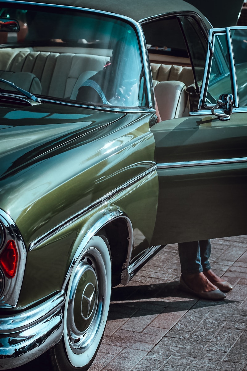 person inside green classic coupe